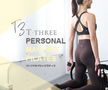 T-THREEのパーソナルマシンピラティスを紹介する広告画像。ピラティスマシンの前に立つ女性を掲載。